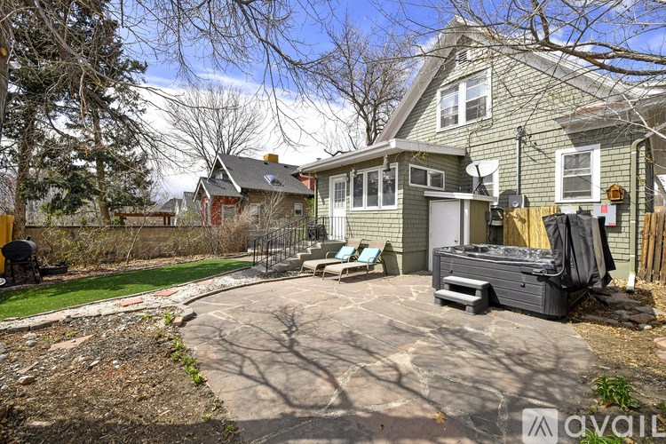 A house with a green exterior and a driveway leading to a garage.