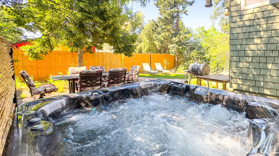 A hot tub in a backyard surrounded by trees.