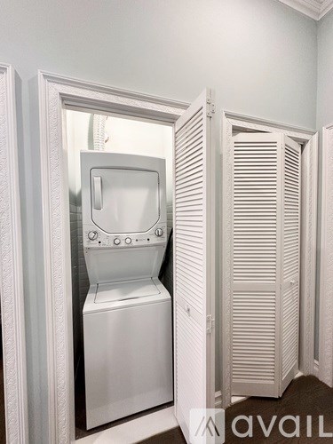 A white washing machine is in a cabinet.