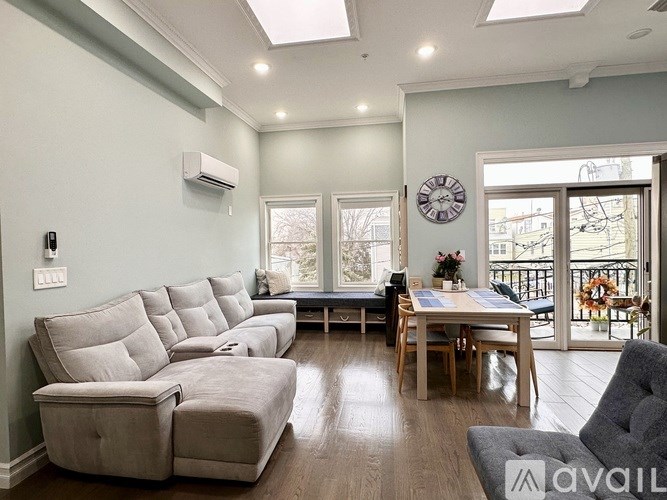 A living room with a long couch and a table with chairs.