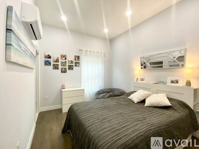 A bedroom with a bed, nightstand, and pictures on the wall.