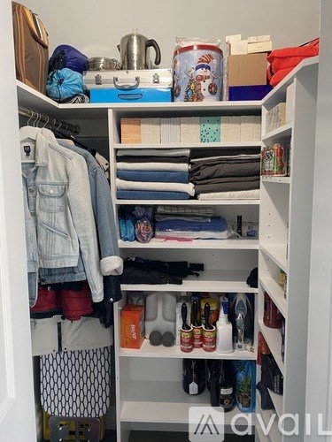 A white closet with a denim jacket hanging on the left side.