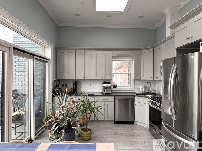 A modern kitchen with stainless steel appliances and a skylight.