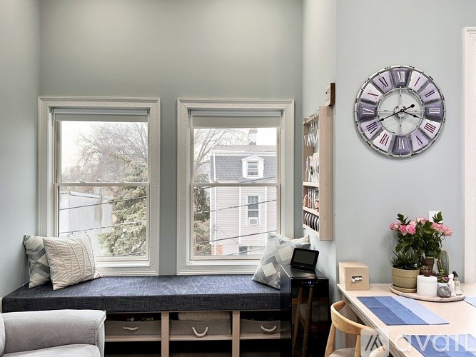 A room with a bed, desk, and a clock on the wall.
