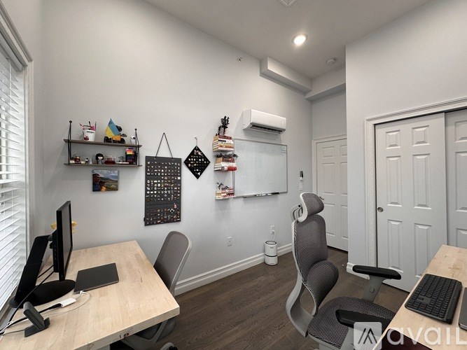 A room with a desk, chairs, and a computer setup.