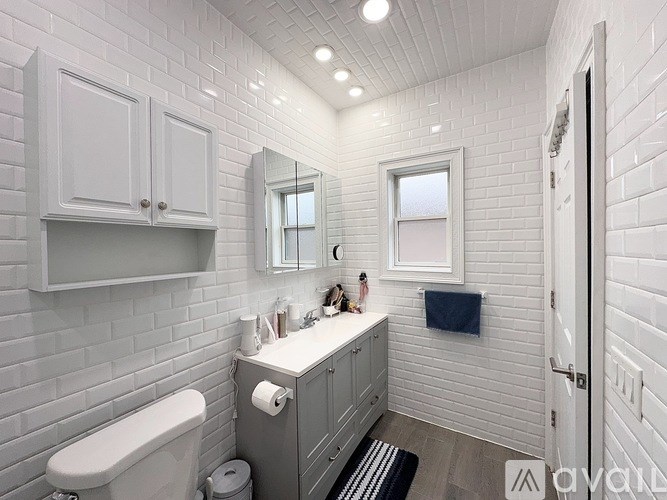 A white bathroom with a toilet, sink, and mirror.