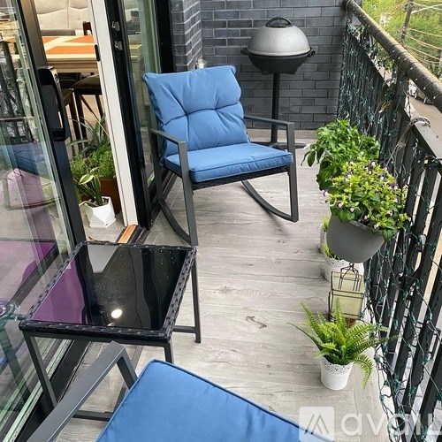 A balcony with a blue chair and a black table.