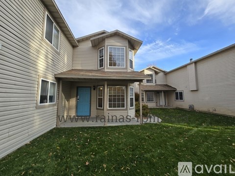 A house with a blue door and a green lawn.