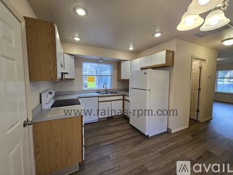 A kitchen with wooden cabinets and a white fridge.