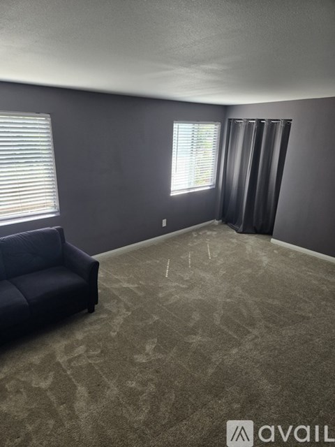A room with a blue couch and a carpeted floor.