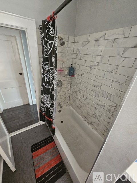 A bathroom with a striped rug on the floor.