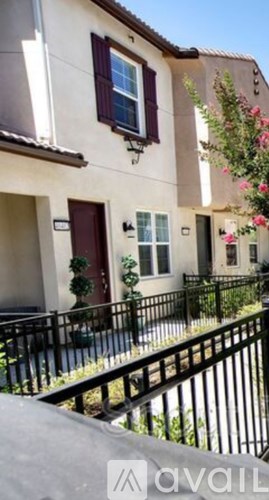 A house with a red door and a black fence.