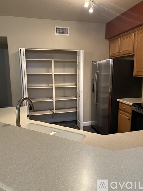 A kitchen with a black refrigerator and a white drawer.