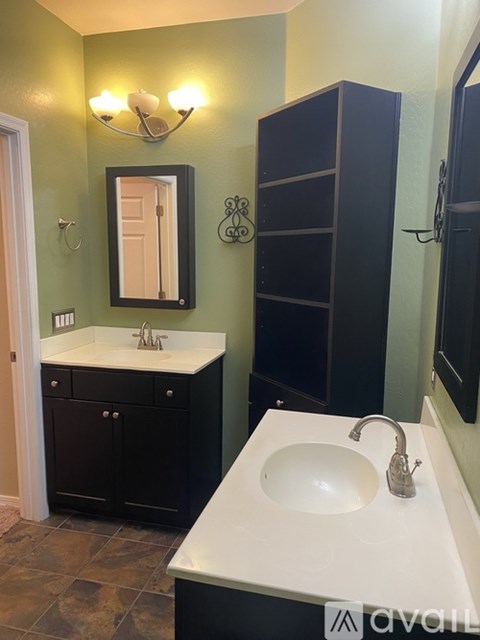 A bathroom with a sink, mirror, and cabinet.