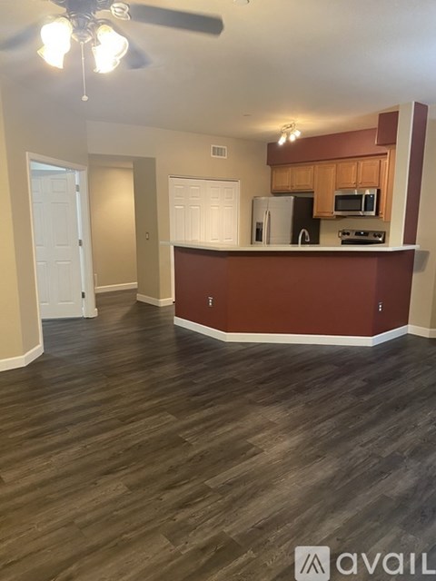 A living room with a kitchenette and hardwood floors.