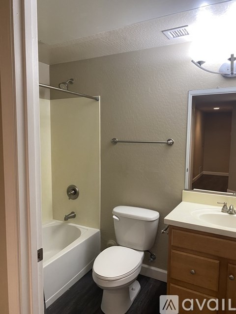 A small bathroom with a toilet, sink, and shower.