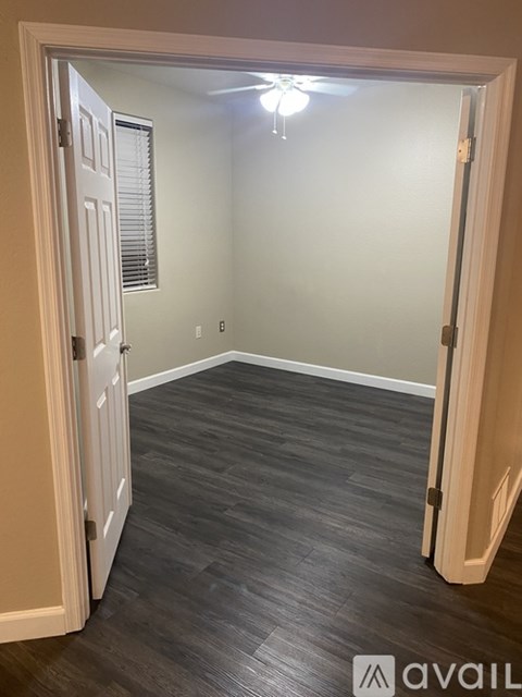 A room with a wooden floor and a ceiling fan.