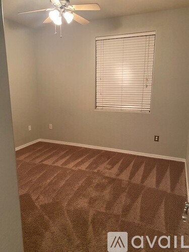 A room with a ceiling fan and carpeted floor.