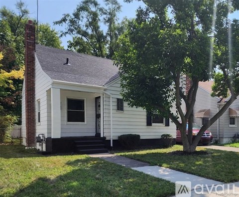 A small white house with a black door and a brick chimney.