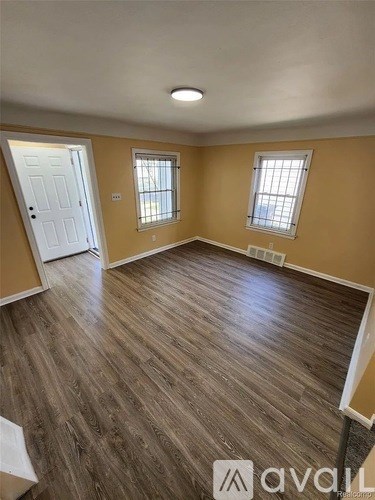 A room with wooden flooring and a white door.