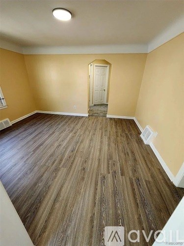 A room with wooden flooring and a white door.