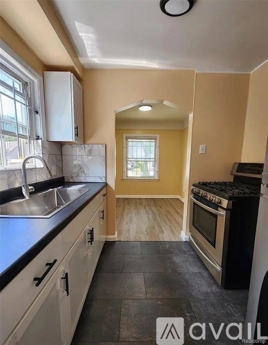 A kitchen with a black stove top oven and a window.