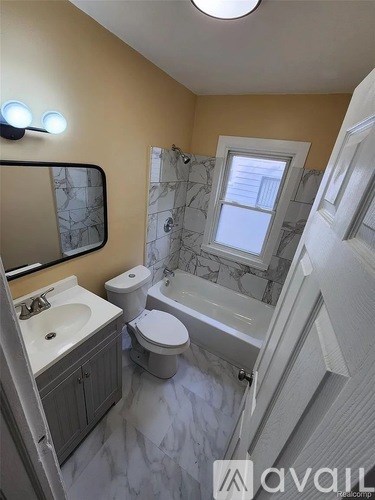 A bathroom with a toilet, sink, and bathtub.
