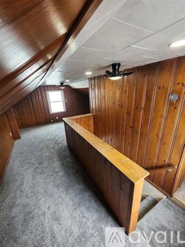 A room with wooden walls and a carpeted floor.