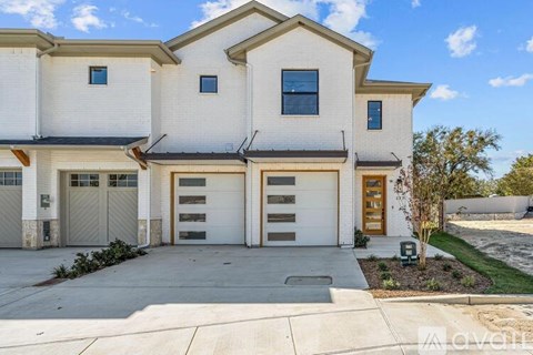 A two-story house with a white exterior and a brown garage door.