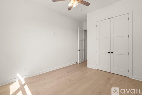 A room with a ceiling fan and two doors.