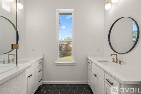 A bathroom with two sinks and a large mirror.