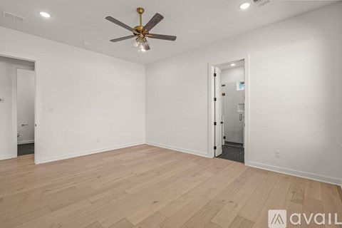 A room with a ceiling fan and wooden flooring.