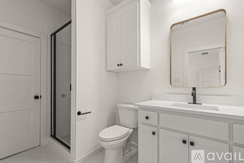 A bathroom with a toilet, sink, and mirror.