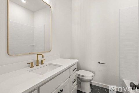 A bathroom with a sink, toilet, and mirror.