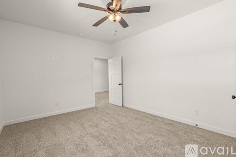 A room with a ceiling fan and carpeted floor.
