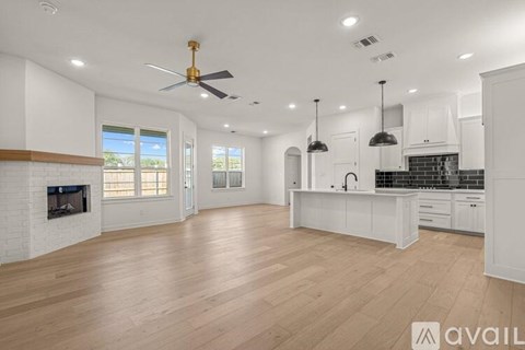A spacious kitchen and living room with hardwood floors and white cabinetry.