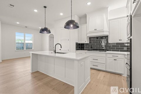 A modern kitchen with white cabinets and a large island.