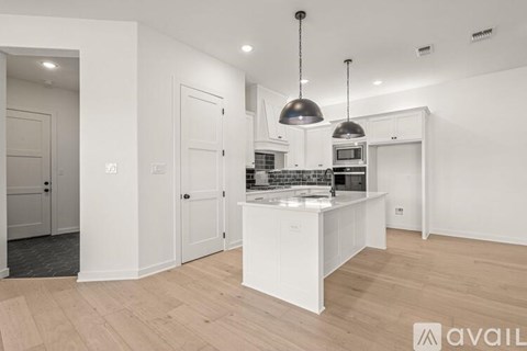 A modern kitchen with white cabinets and a central island.