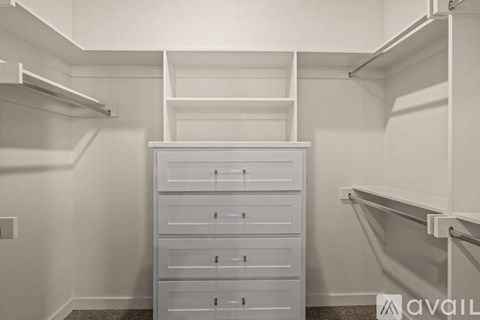 A white closet with a shelf and drawers.
