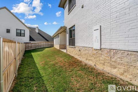 A white house with a wooden fence and a grassy yard.