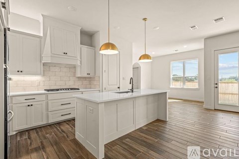 A kitchen with white cabinets and a wooden floor.
