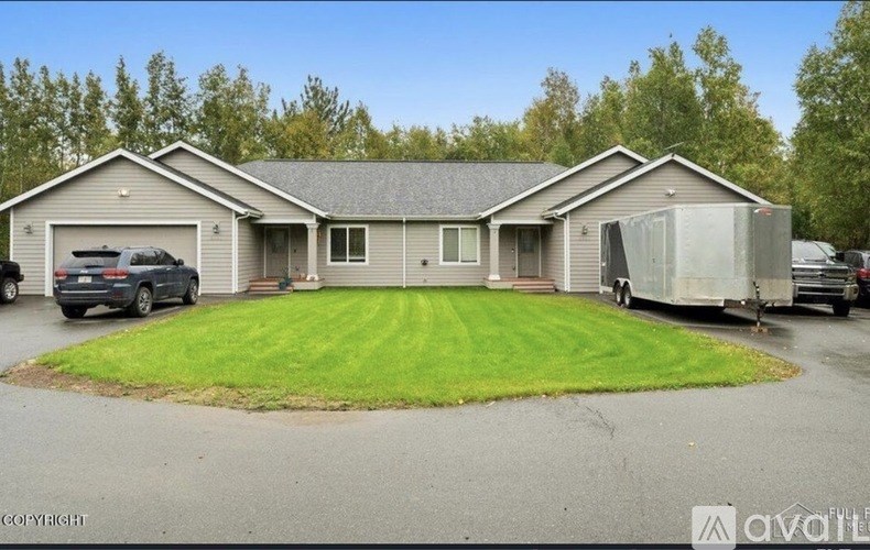 A house with a grey roof and a green lawn in front.