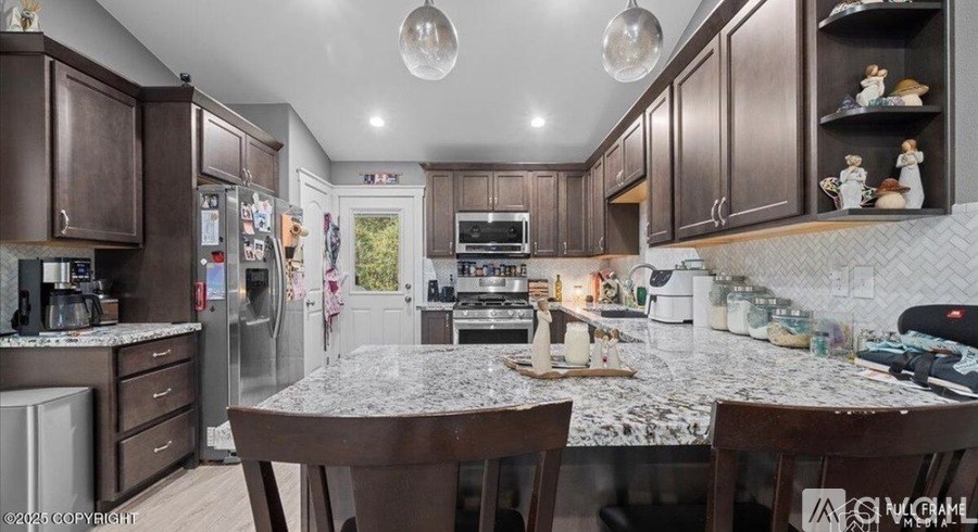 A kitchen with brown cabinets and a granite countertop.