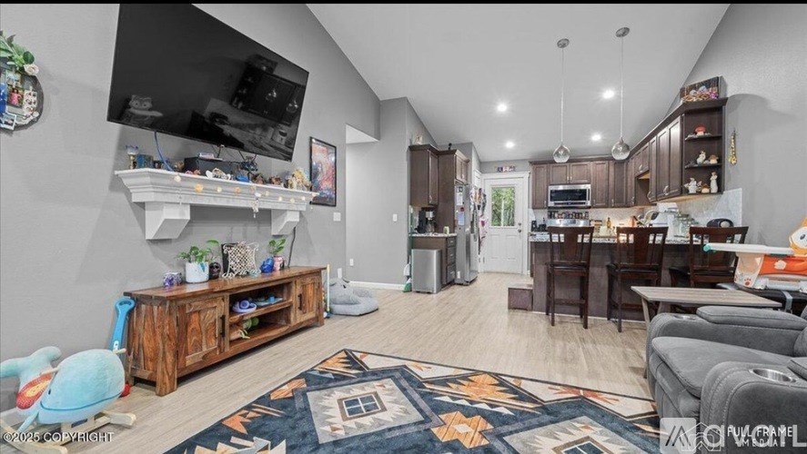 A living room with a television, a couch, and a rug.