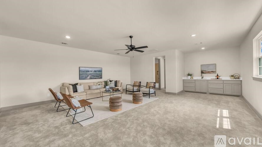 A spacious living room with a sofa set, chairs, and a ceiling fan.