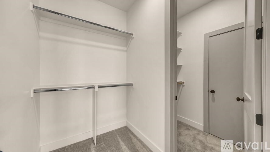 A white wall with a shelf and a door.