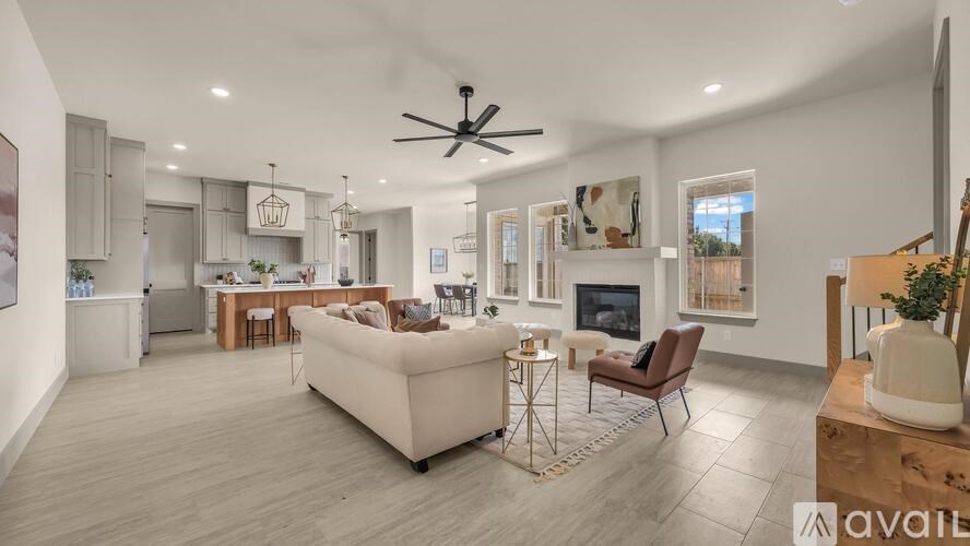 A spacious living room with a white sofa set and a fireplace.