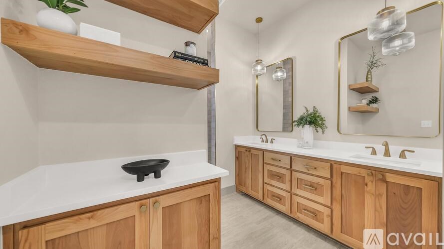 A modern bathroom with wooden cabinets and a white countertop.