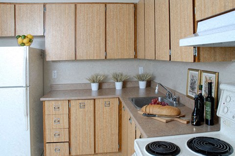 A kitchen with wooden cabinets and a white stove top.