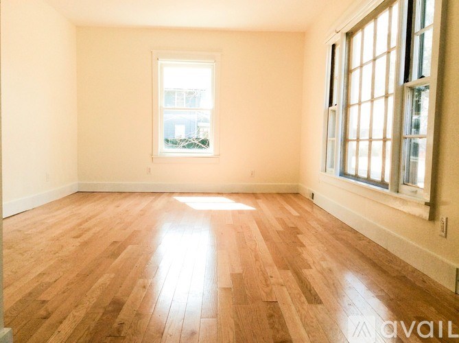 A room with wooden flooring and a window.